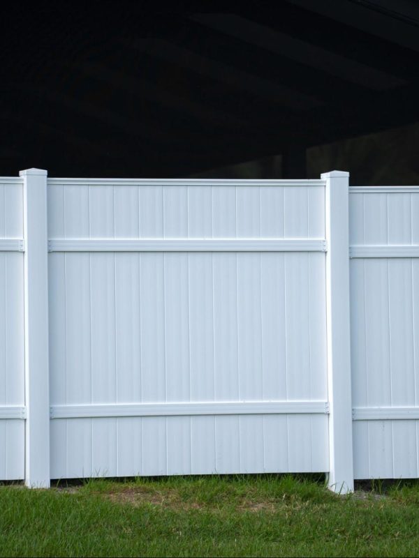 Vinyl fence on a grassy yard.