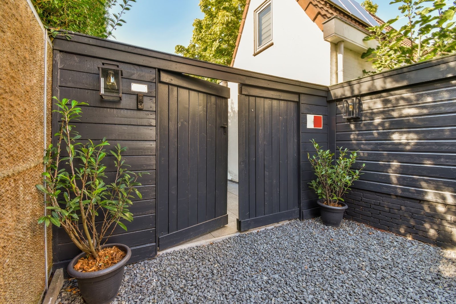 An exterior view of an open gate that leads to a home.