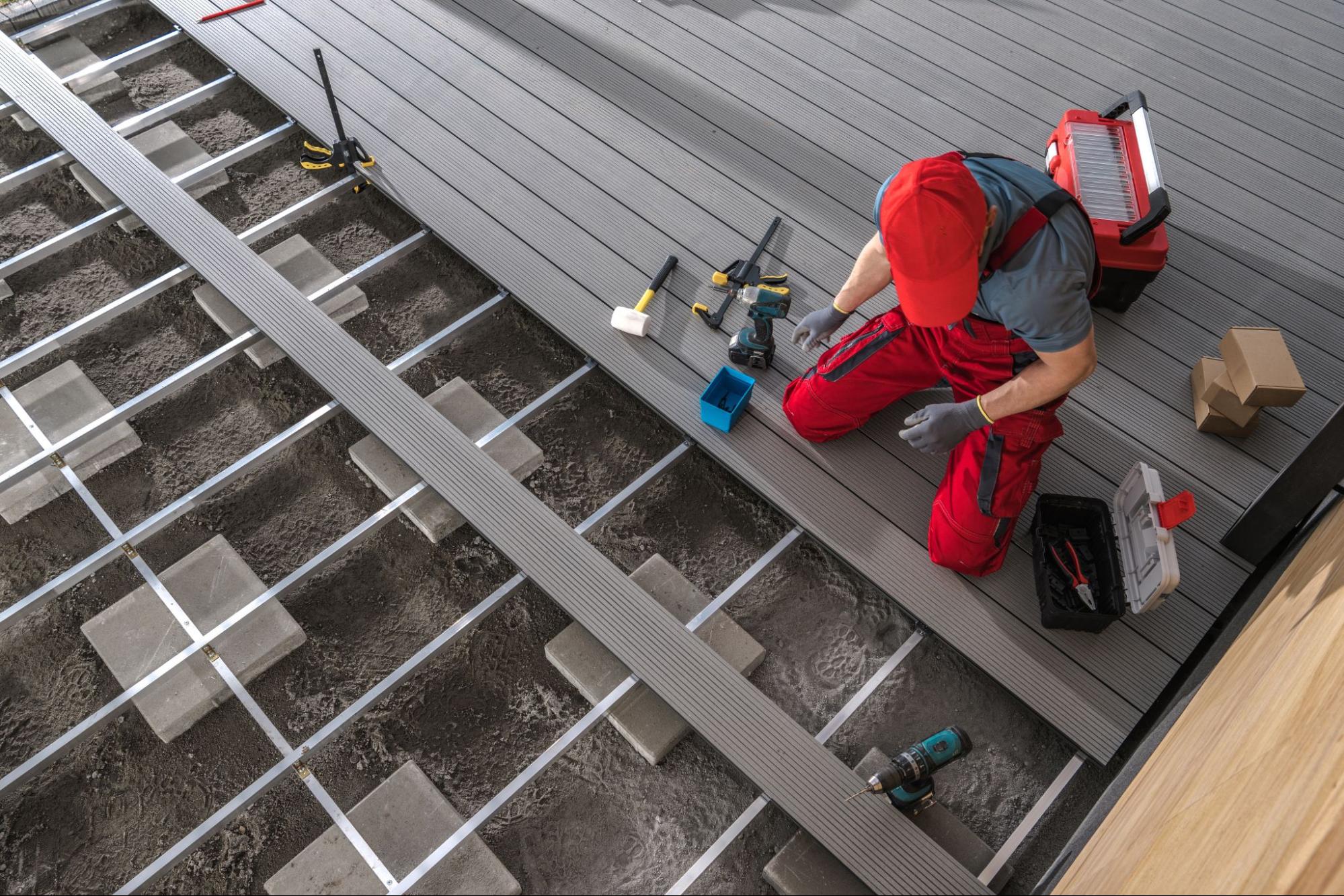 A contractor installing composite gray-colored decking planks.