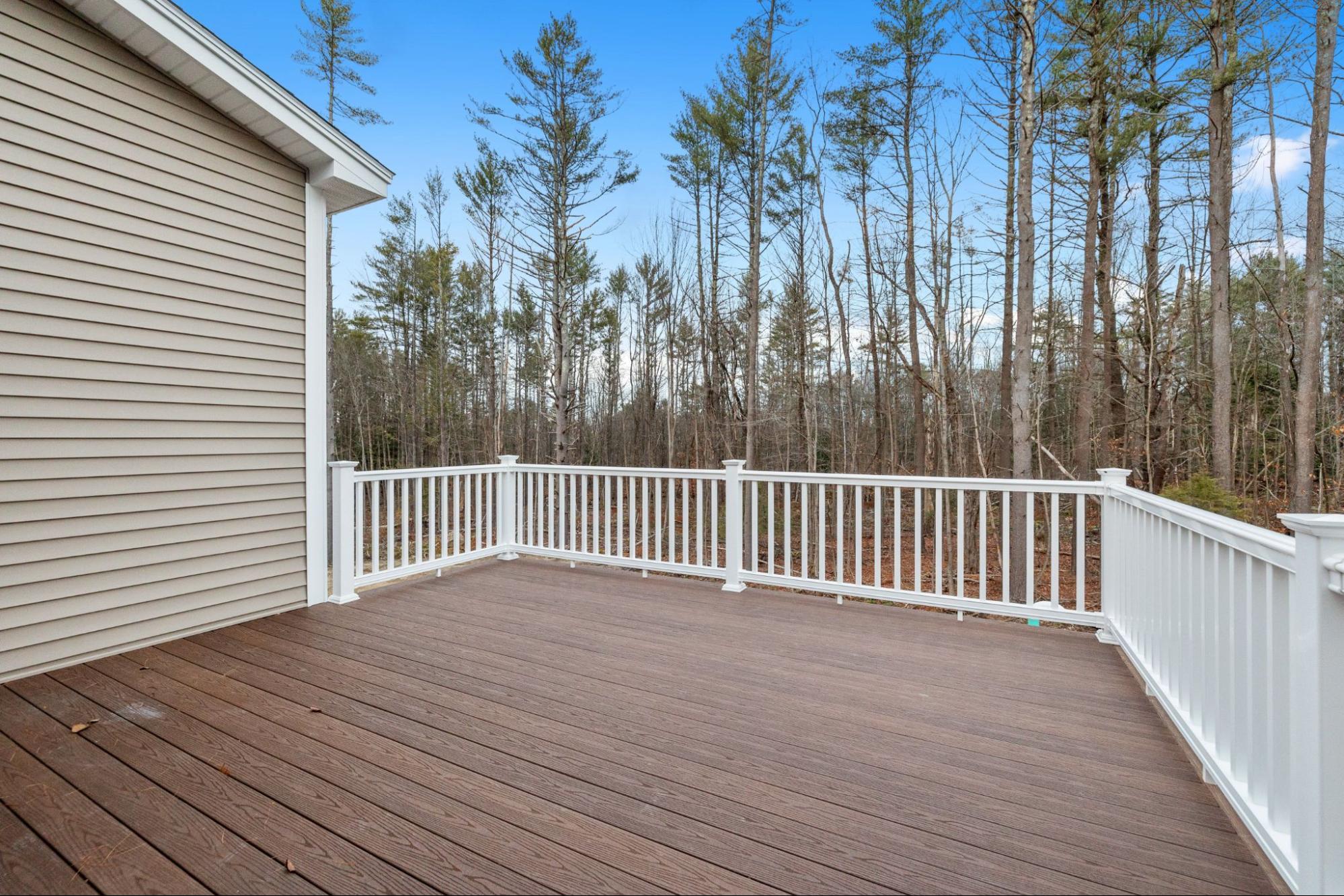 Decking boards of a porch with white railings.