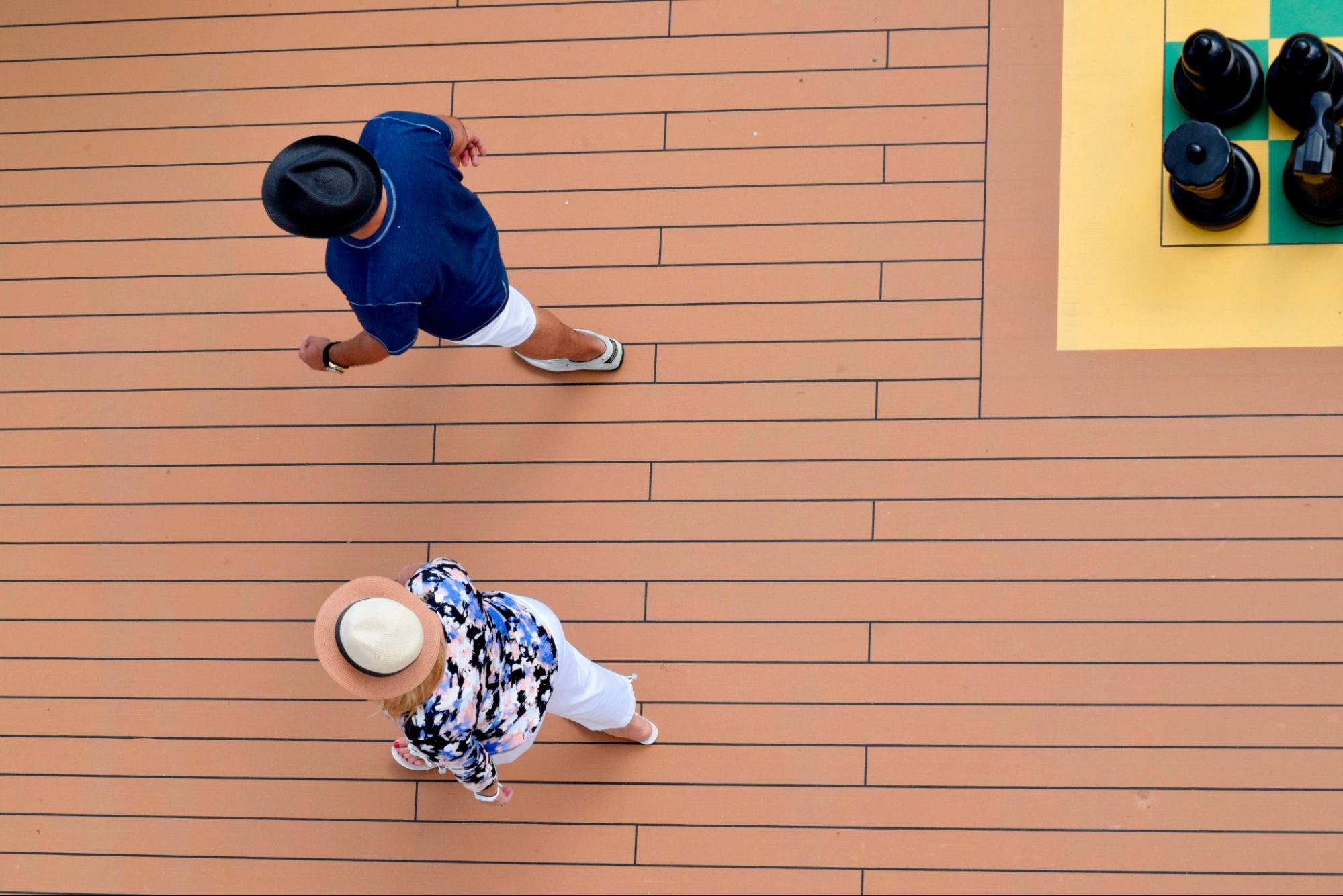 An aerial view of a senior couple walking along a composite deck.