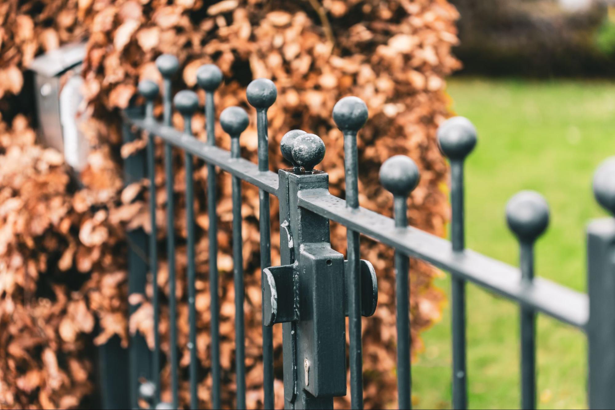 Aluminum fence with a garden in the background.