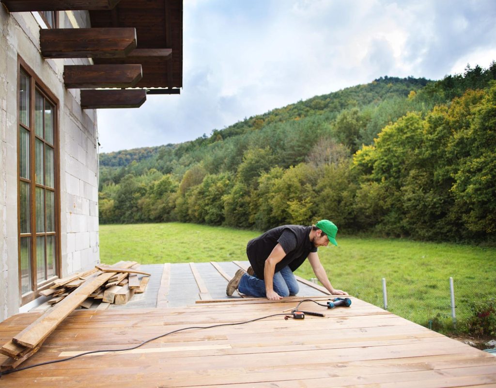 A handyman assembling planks for deck building.