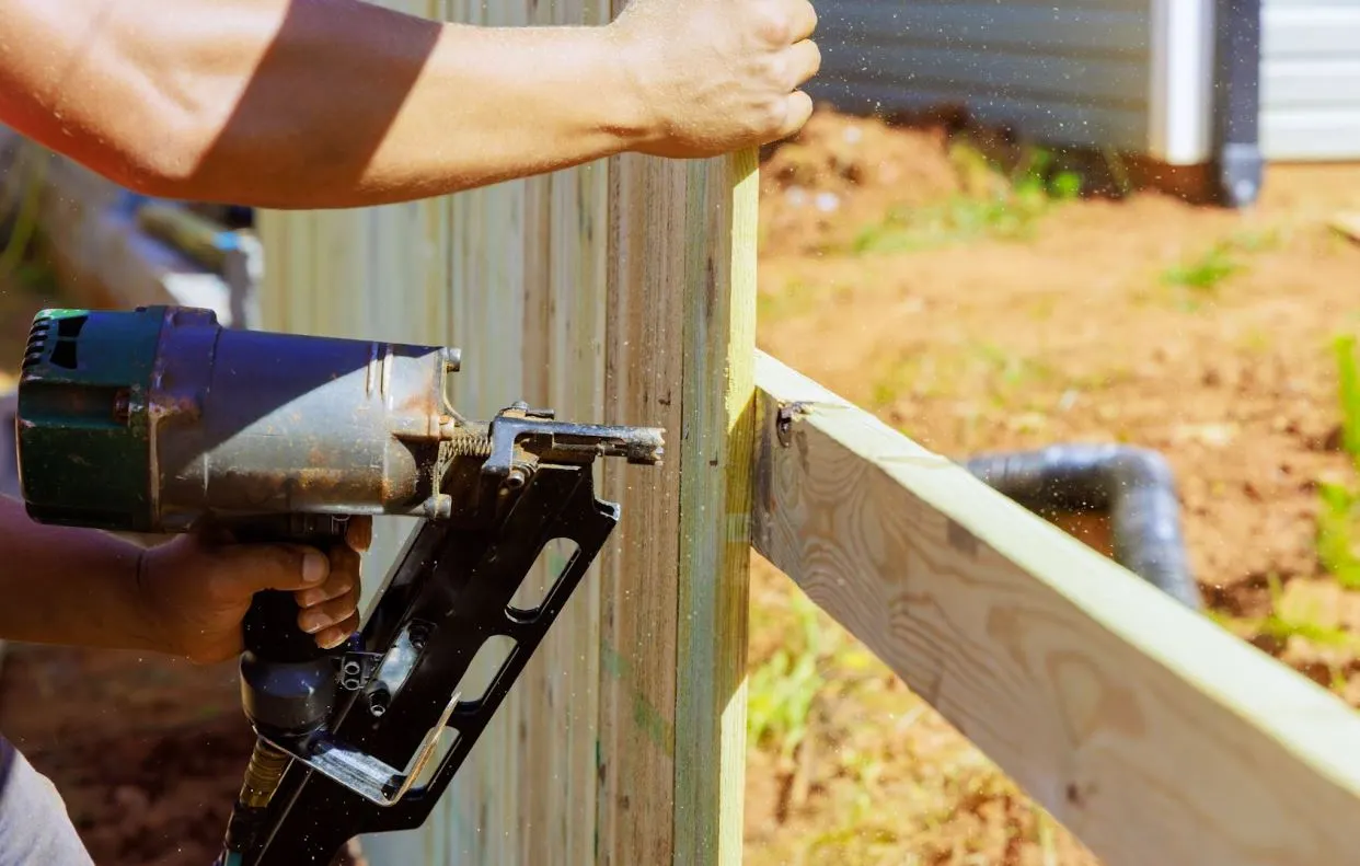 Man installing wood fencing.