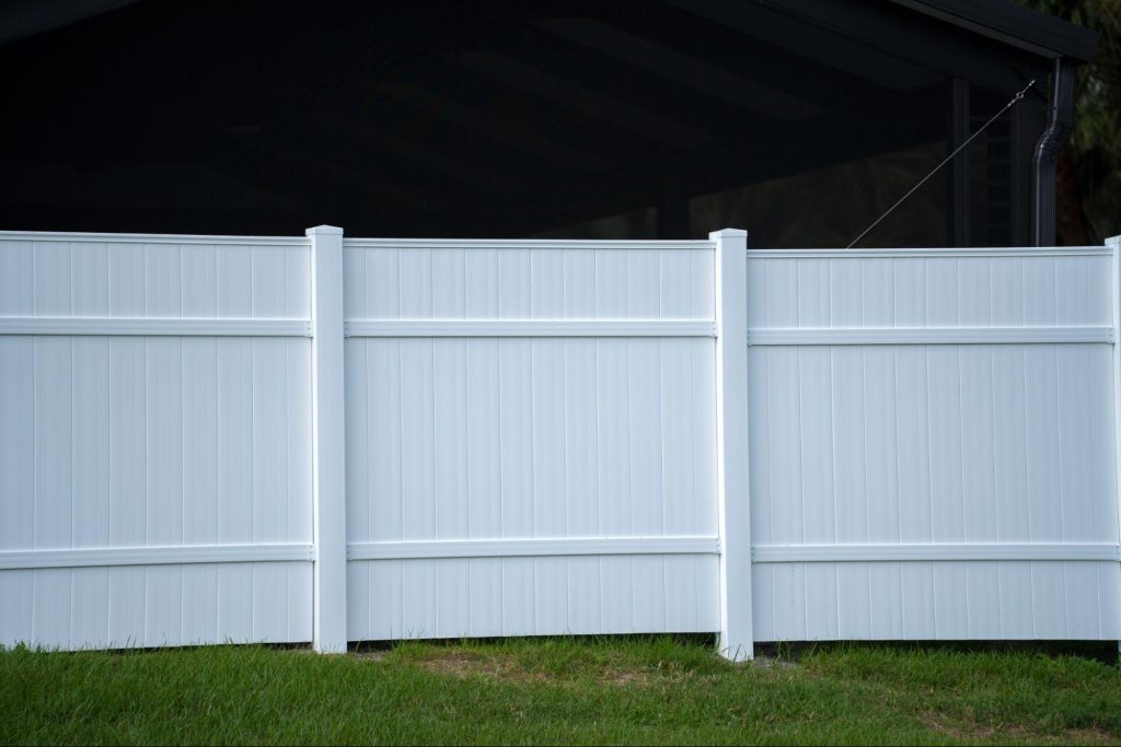 Vinyl fence on a grassy yard.