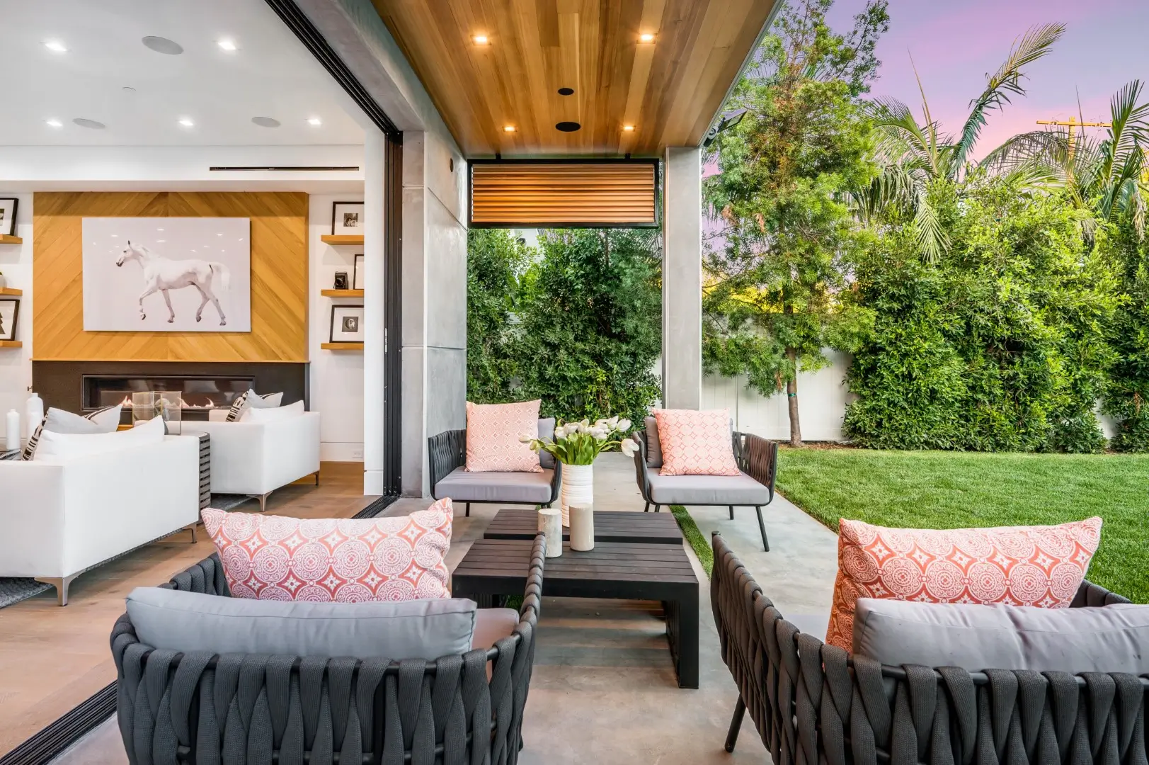 A backyard with outside furniture under a covered patio.