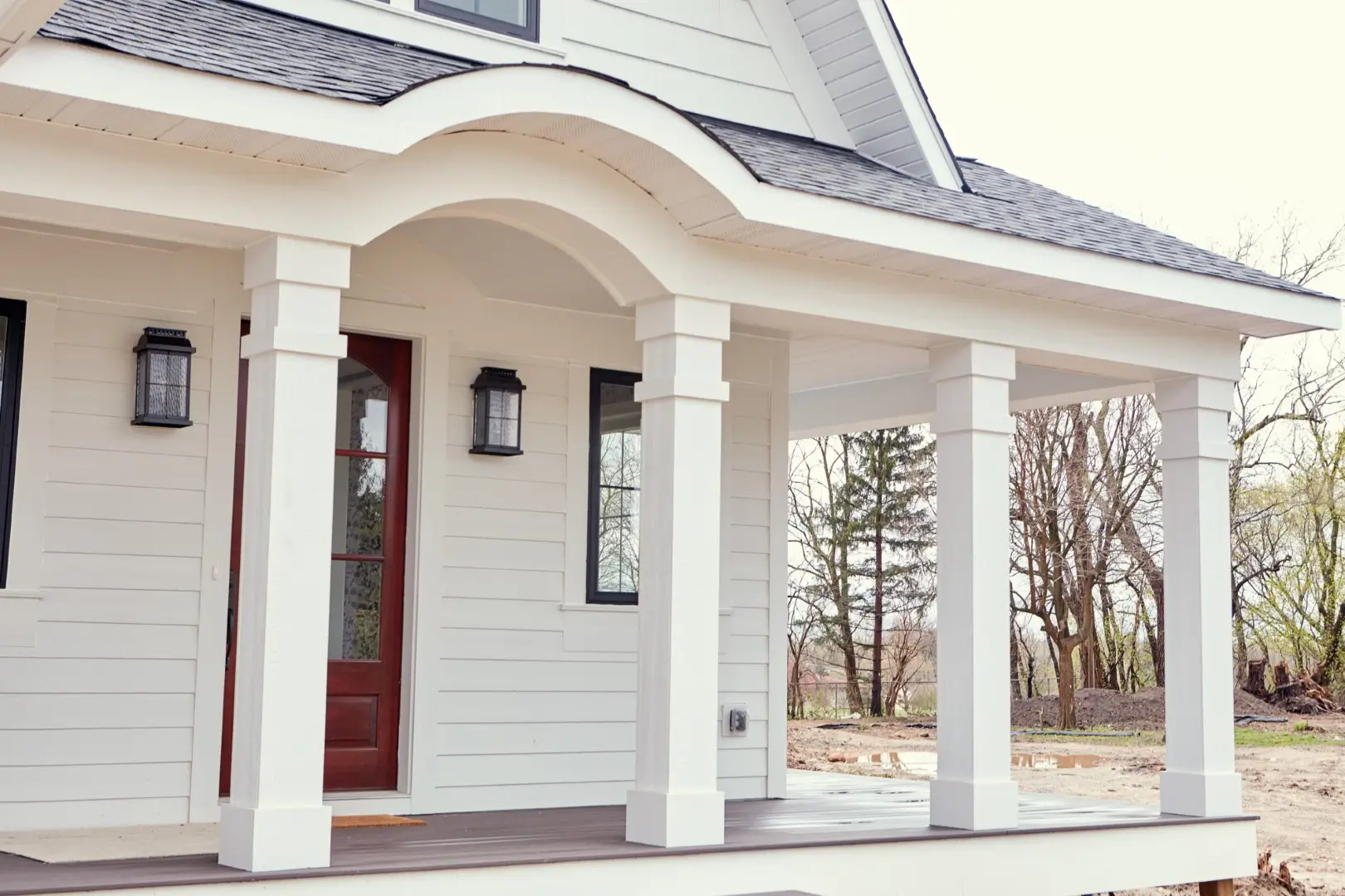 A close up view of a white house with a front porch.