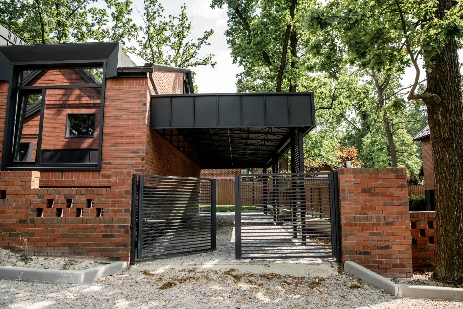 A row of modern townhouses enclosed by black, sleek steel fence panels.