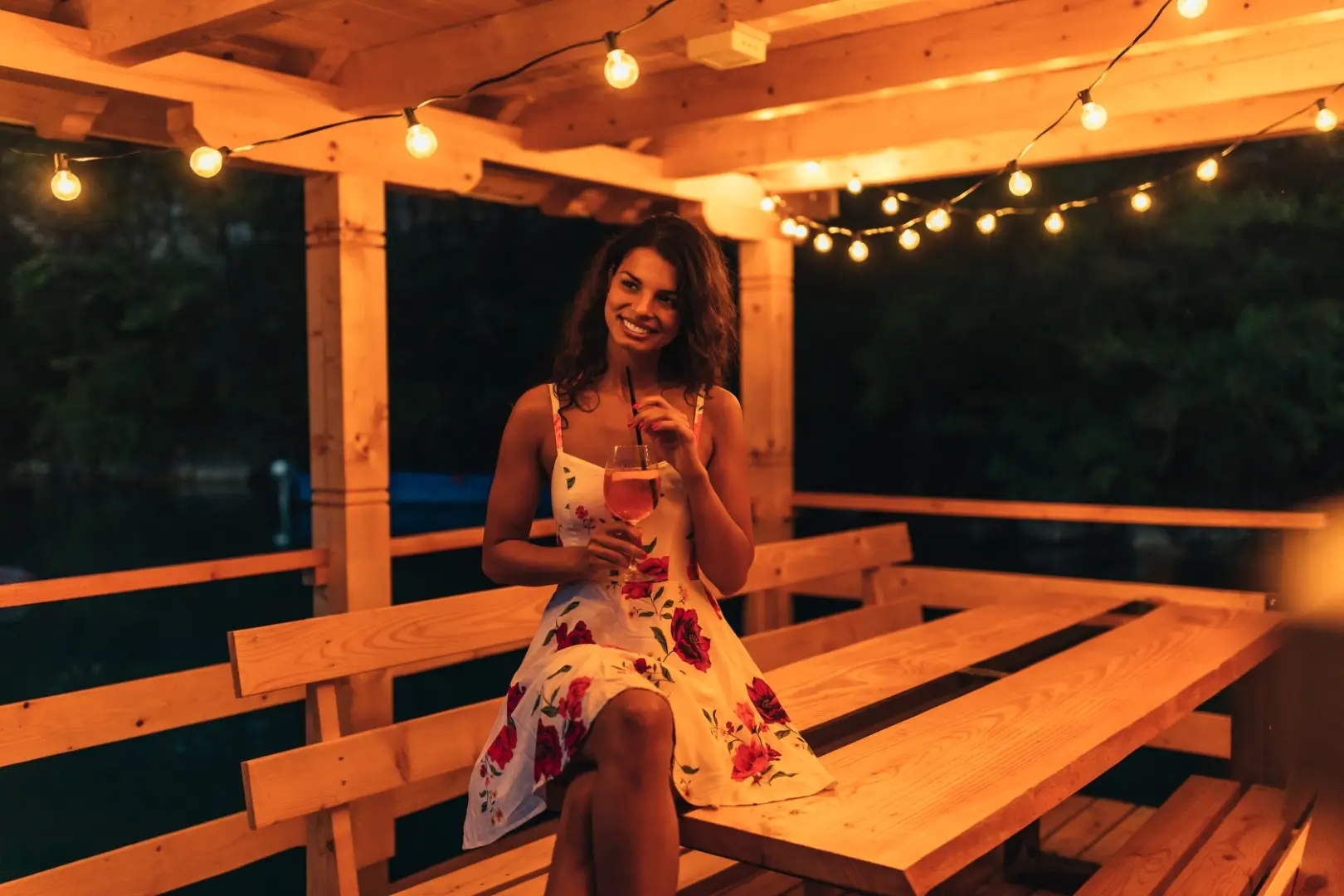 A string of lights lightens a wooden porch.