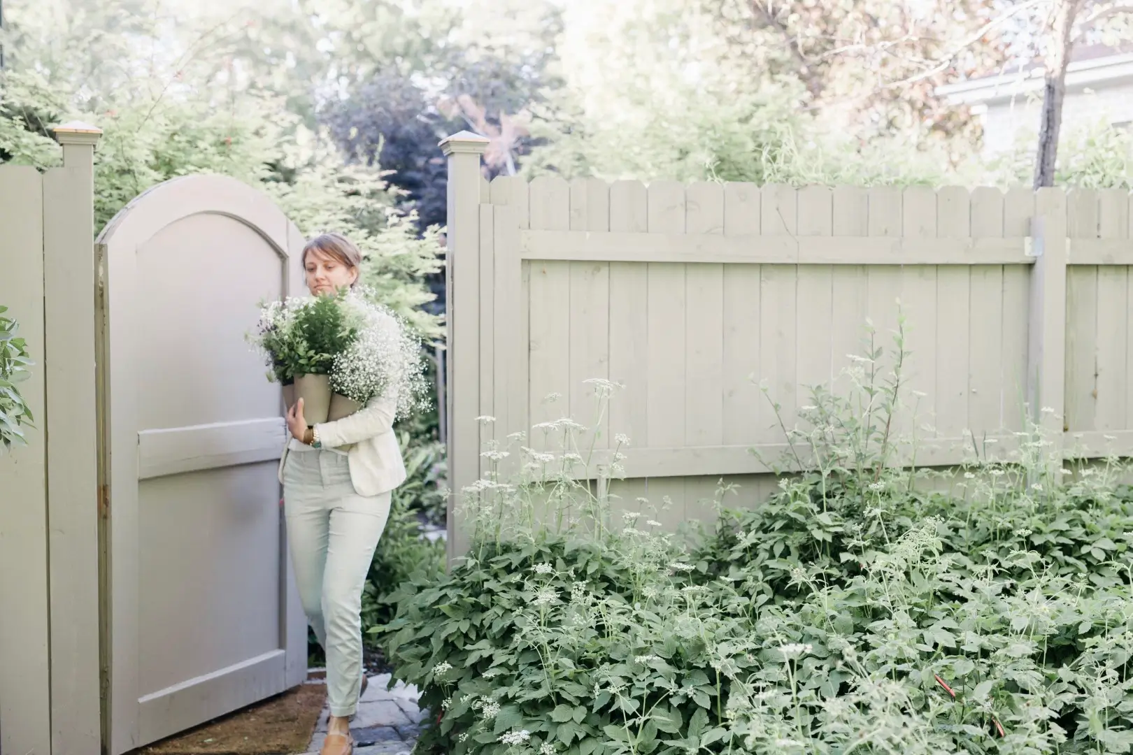 A white fence surrounds someone's property, creating privacy.