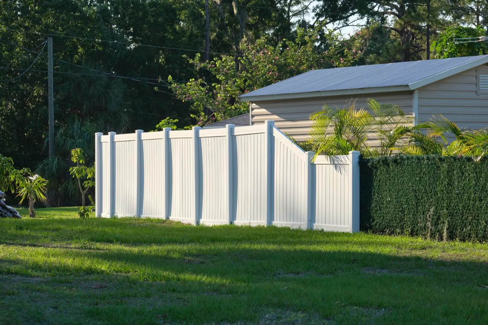 A white vinyl privacy fence providing backyard security and seclusion.
