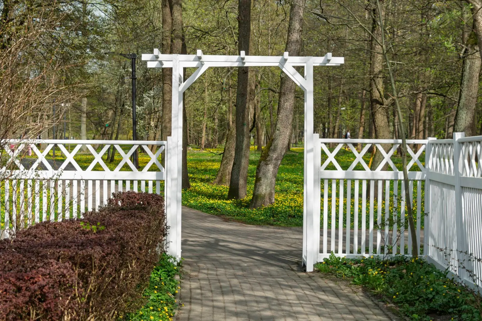 A white wooden outdoor gate that’s open.