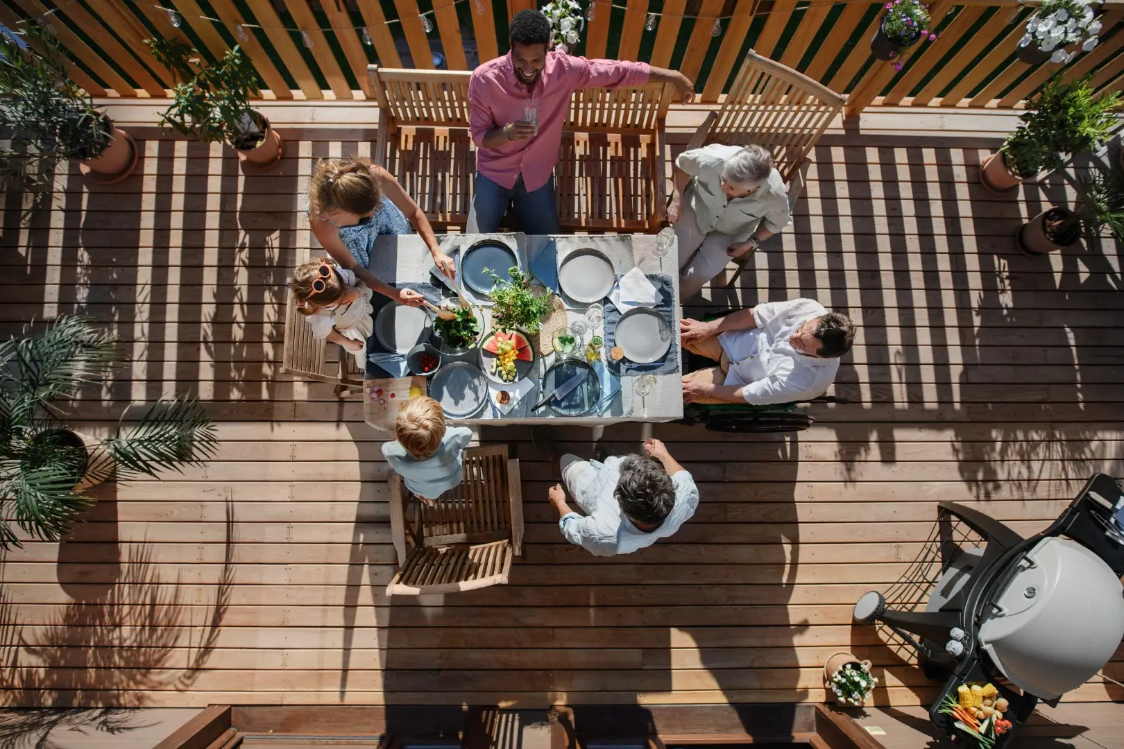 An overview of a family enjoying a meal on a patio deck.