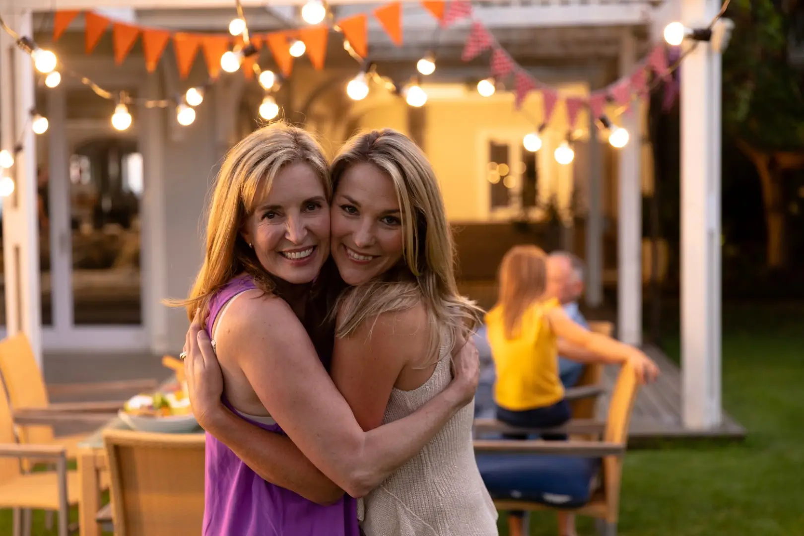 Friends pose under a vinyl-covered patio.