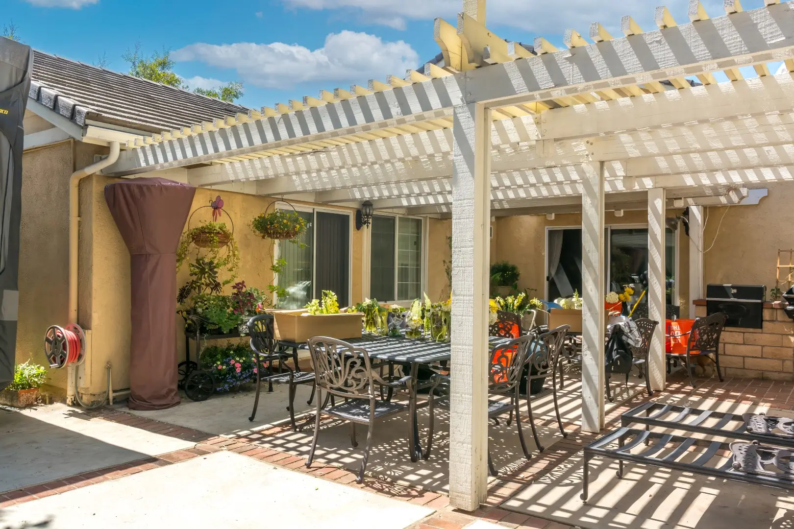 Outdoor patio featuring tables, chairs, and a barbecue grill.