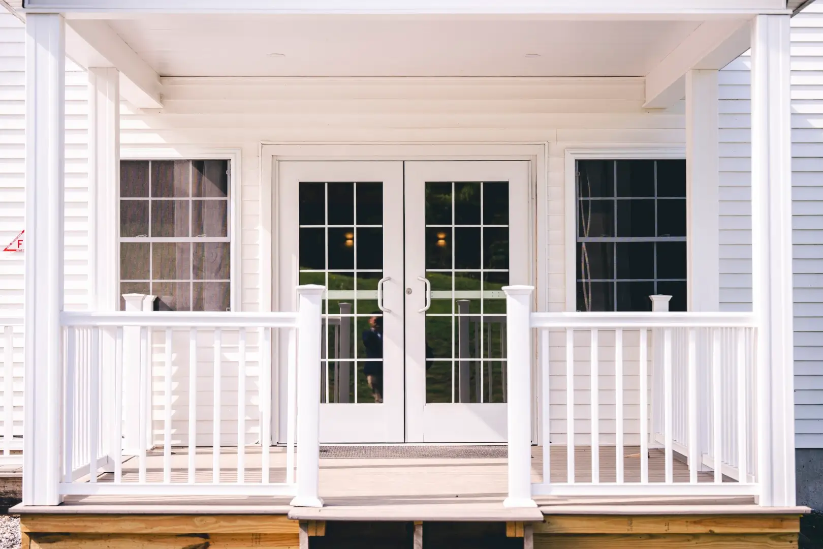 Vinyl deck railing in front of glass doors and windows.