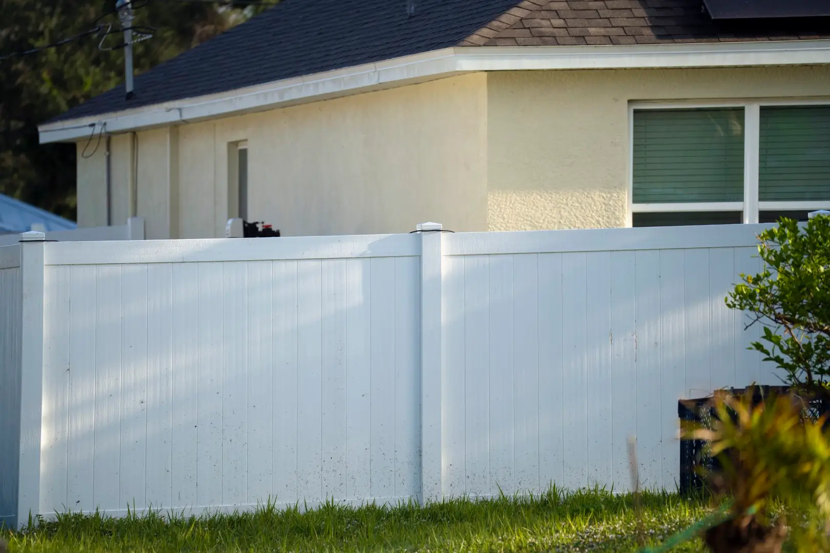 Vinyl fence on the side of a home with a gate.