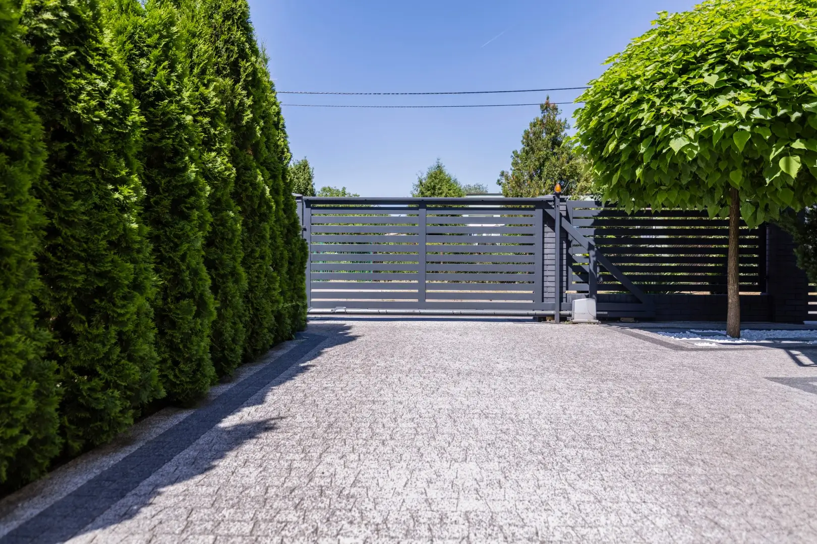 Anthracite-colored panel fence with a visible sliding gate.