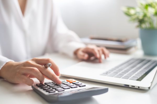 Woman entrepreneur using calculator.