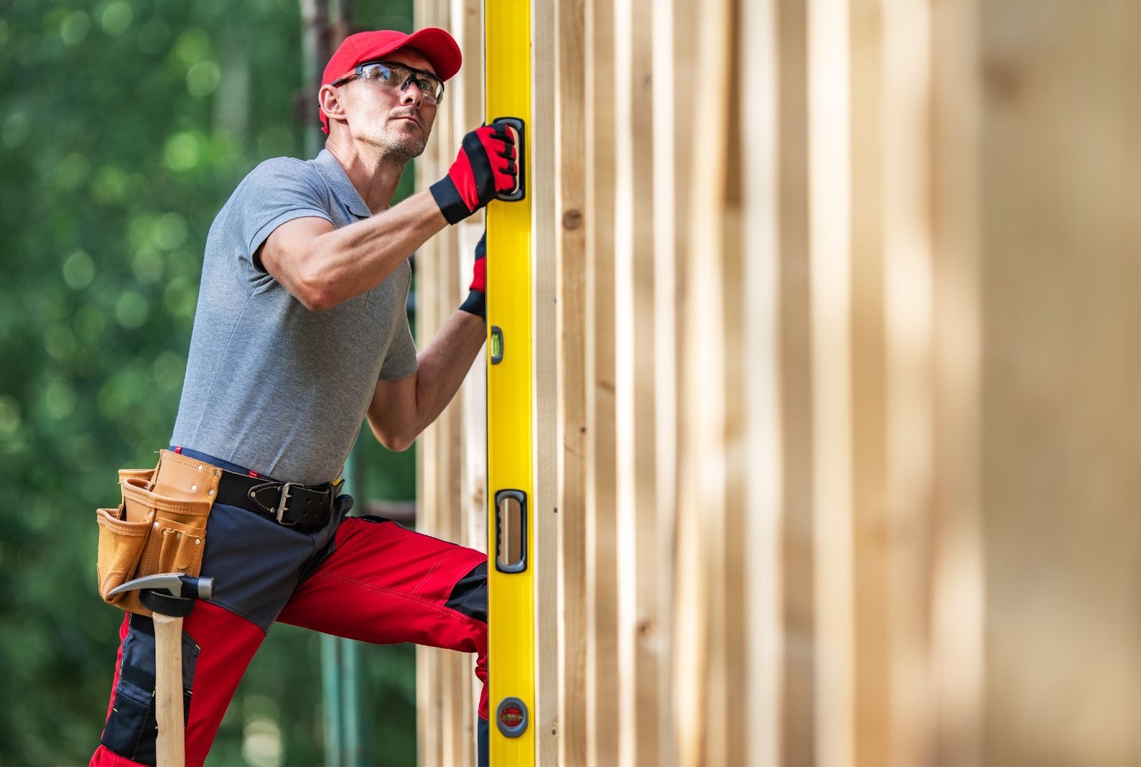 Fence contractor checking fence height with a bubble spirit level on-site