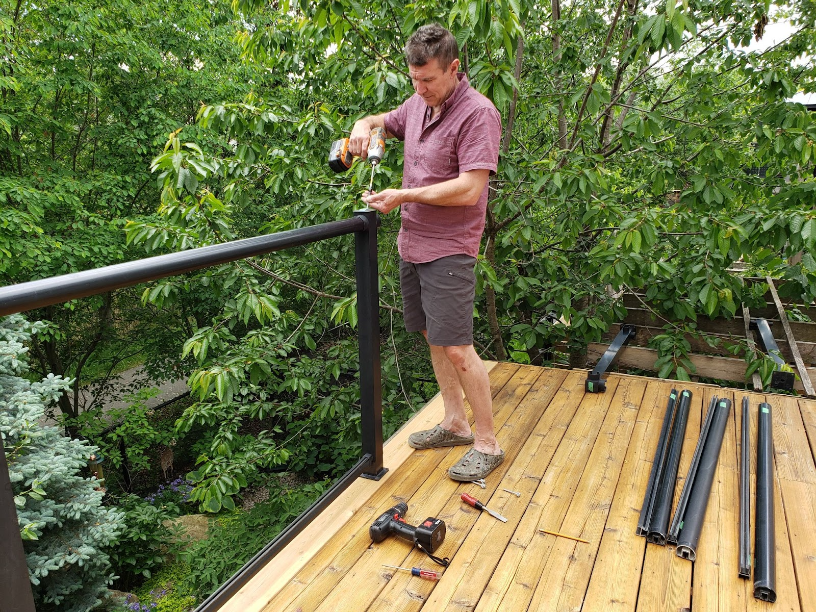 A male worker installs the gate fences with an electric screwdriver.