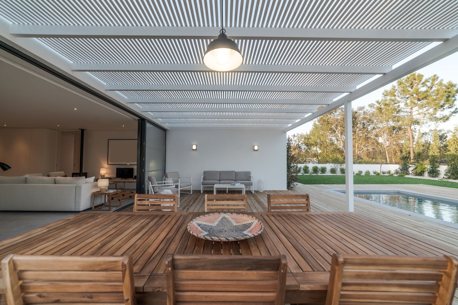 Modern home with a vinyl lattice patio cover overlooking a garden, swimming pool, and wooden deck for stylish outdoor living.