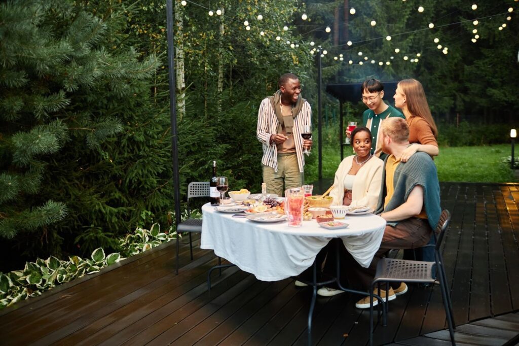 Adult friends have a dinner party on their backyard deck.