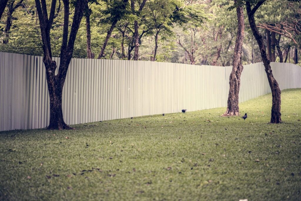 A large aluminum fence running along the edge of a property.