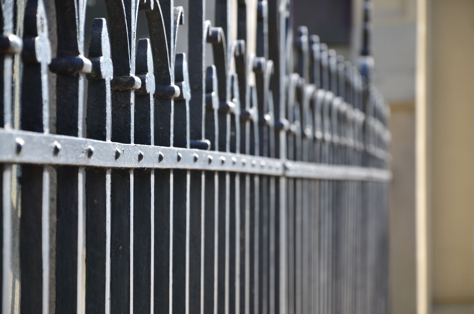 Close-up view of a decorative metal fence featuring intricate patterns and smooth, polished detailing