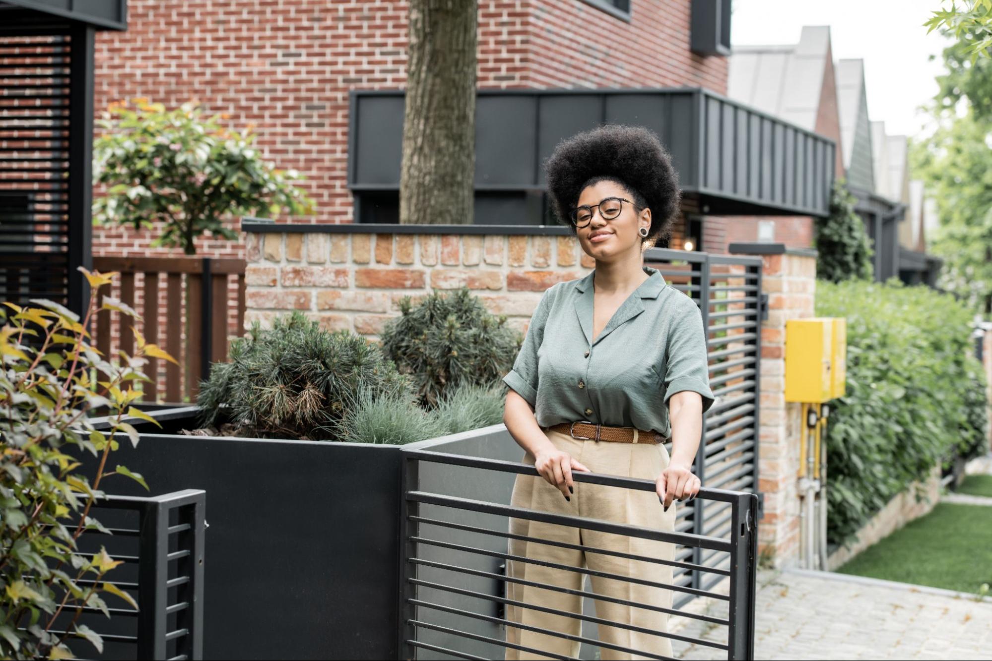Woman next to a steel fence.