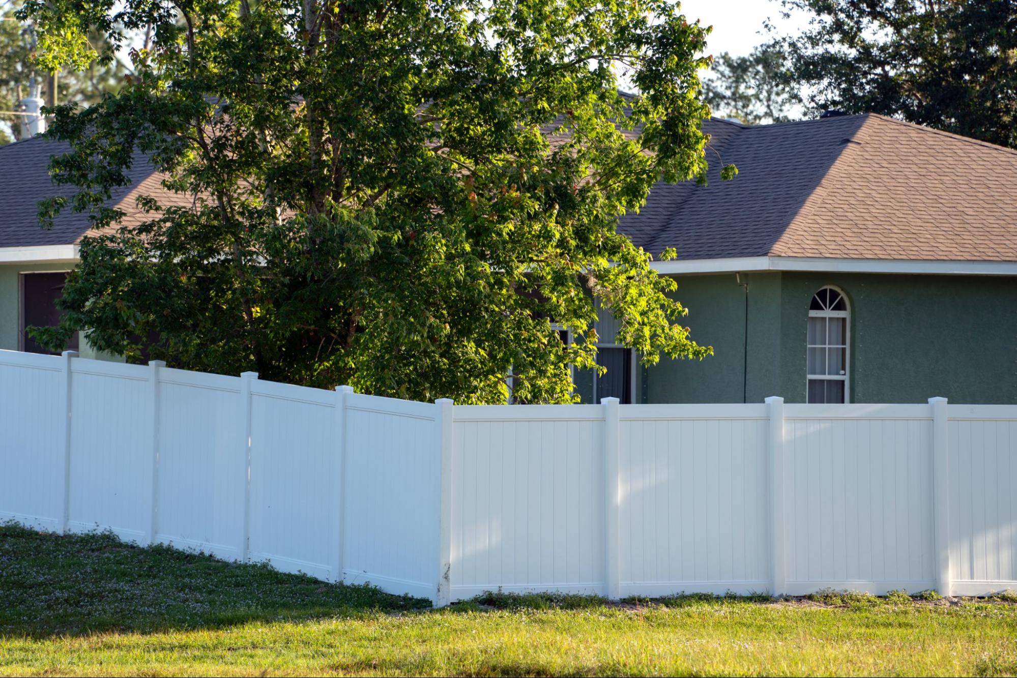 A white vinyl privacy fence enclosing a secure backyard space.