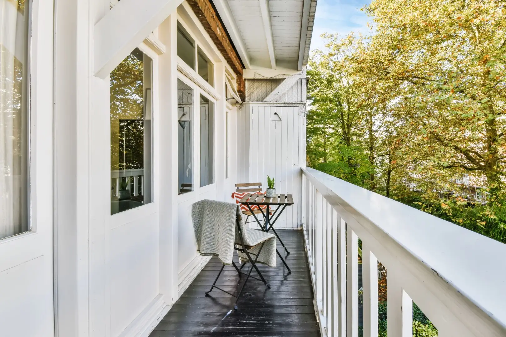 White balcony featuring a table and chair set.